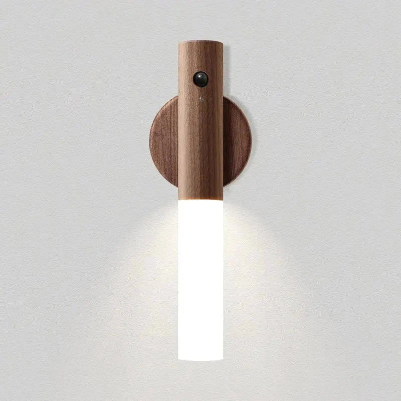 Walnut motion sensor night light glowing on its round wall mount