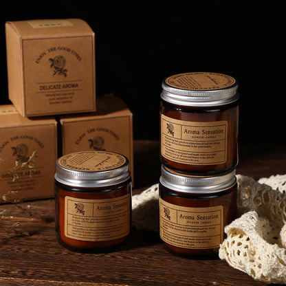 Amber glass scented candles stacked with their gift boxes