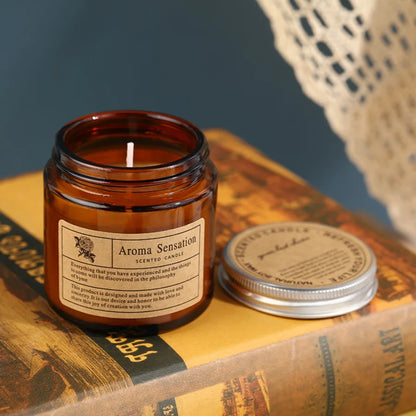 Lit amber glass scented candle on a stack of books