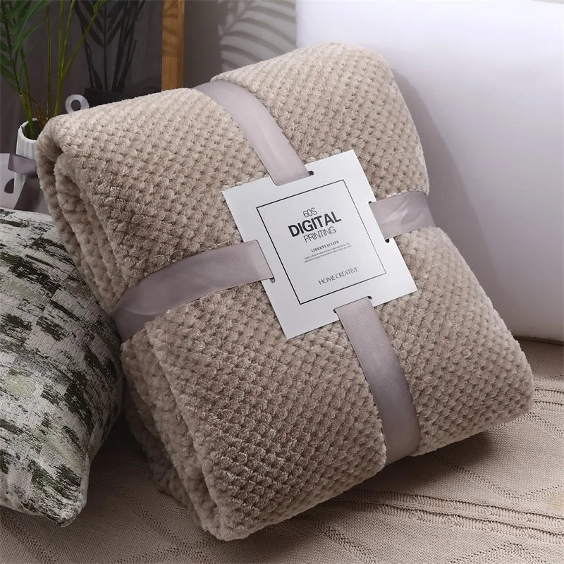 Khaki plush fleece blanket rolled beside a cushion