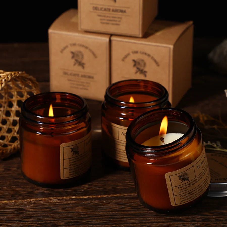 Three lit scented candles in amber glass jars