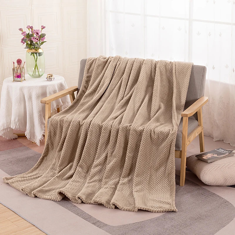 Beige plush fleece blanket draped over an armchair