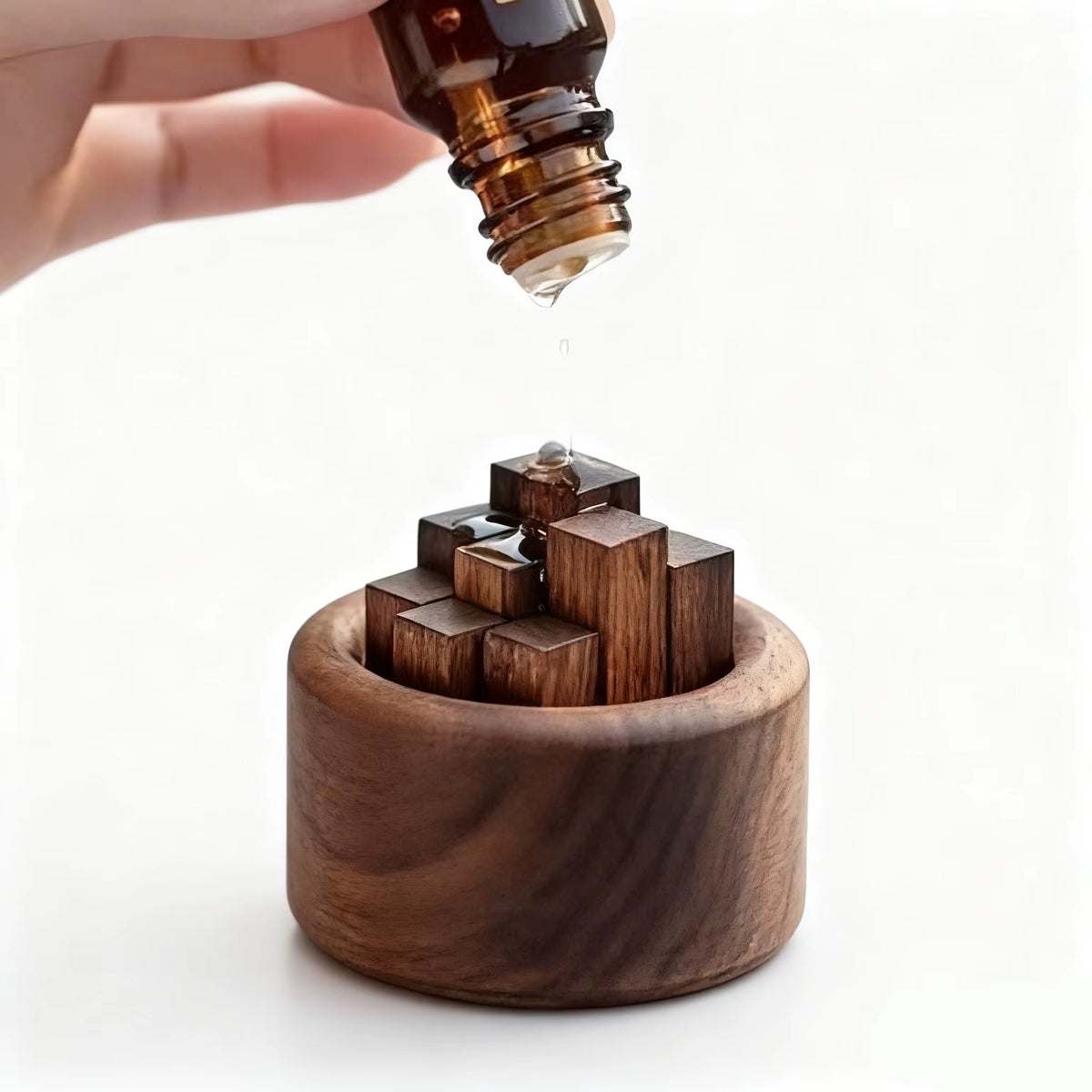 Adding essential oil drops to the wooden fragrance diffuser