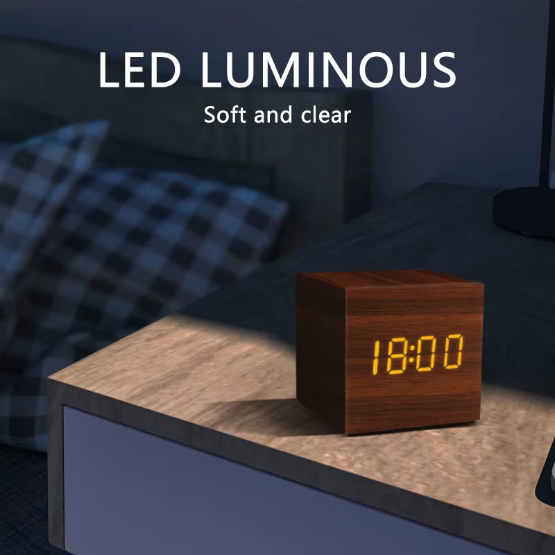 Square brown wooden LED clock glowing on a bedside table